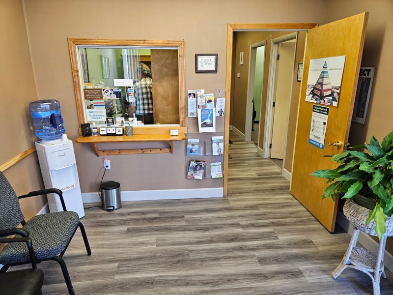An image of the Gowanda Chiropractic office is show with the waiting room at 18 E Main St. Featuring a plant, friendly staff and a water machine.